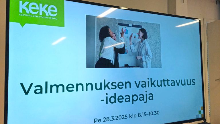 Televisiolla näkyvä PowerPoint-dia. Dian ylälaidassa on kestävän kehityksen keskuksen logo. Diassa lukee: "Valmennuksen vaikuttavuus -ideapaja. Perjantaina 28.3.2025 klo 8.15-10.30.