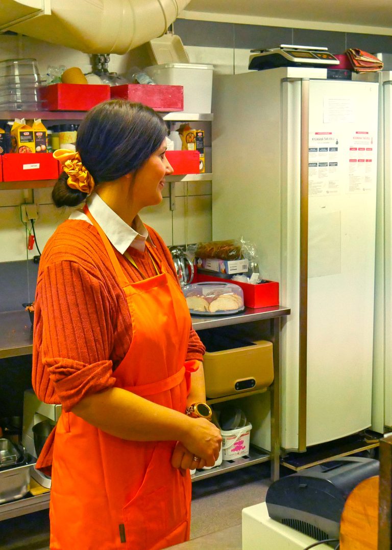 Rosalie seisoo keittiössä essu päällään.