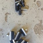 Irrallaan lattialla olevia pyörän jarrupaloja. Palat on aseteltu kahteen pieneen kasaan.