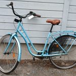 Vaalean sininen 28 -tuumainen kolmi -vaihteinen Raleigh Classic -merkkinen matalarunkoinen kaupunkipyörä. Pyörässä on useita heijastimia, tarakka, musta tavarasuoja, soittokello, seisontatuki, käsin toimiva etujarru, ruskeapenkki, ruskeat ohjaustangon tupet.