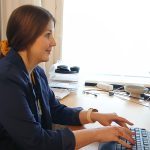 Työllisyyspalvelupäällikkö Rosalie Leskelä istuu Sorvi-toimipaikan hanketoimistolla tietokoneen ääressä. Työpöydällä on tietokoneen lisäksi dokumentteja sekä ikkunan viereen asetettu ruukkukasvi.