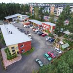 DCIM100MEDIADJI_0069.JPG Kesäinen Sorvi-toimipaikka ilmasta nähtynä. Piha on täynnä autoja ja polkupyöriä.